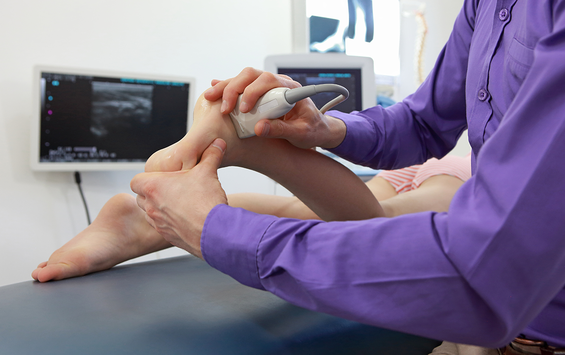 Healthcare professional analyzing an ultrasonography image for musculoskeletal injury assessment